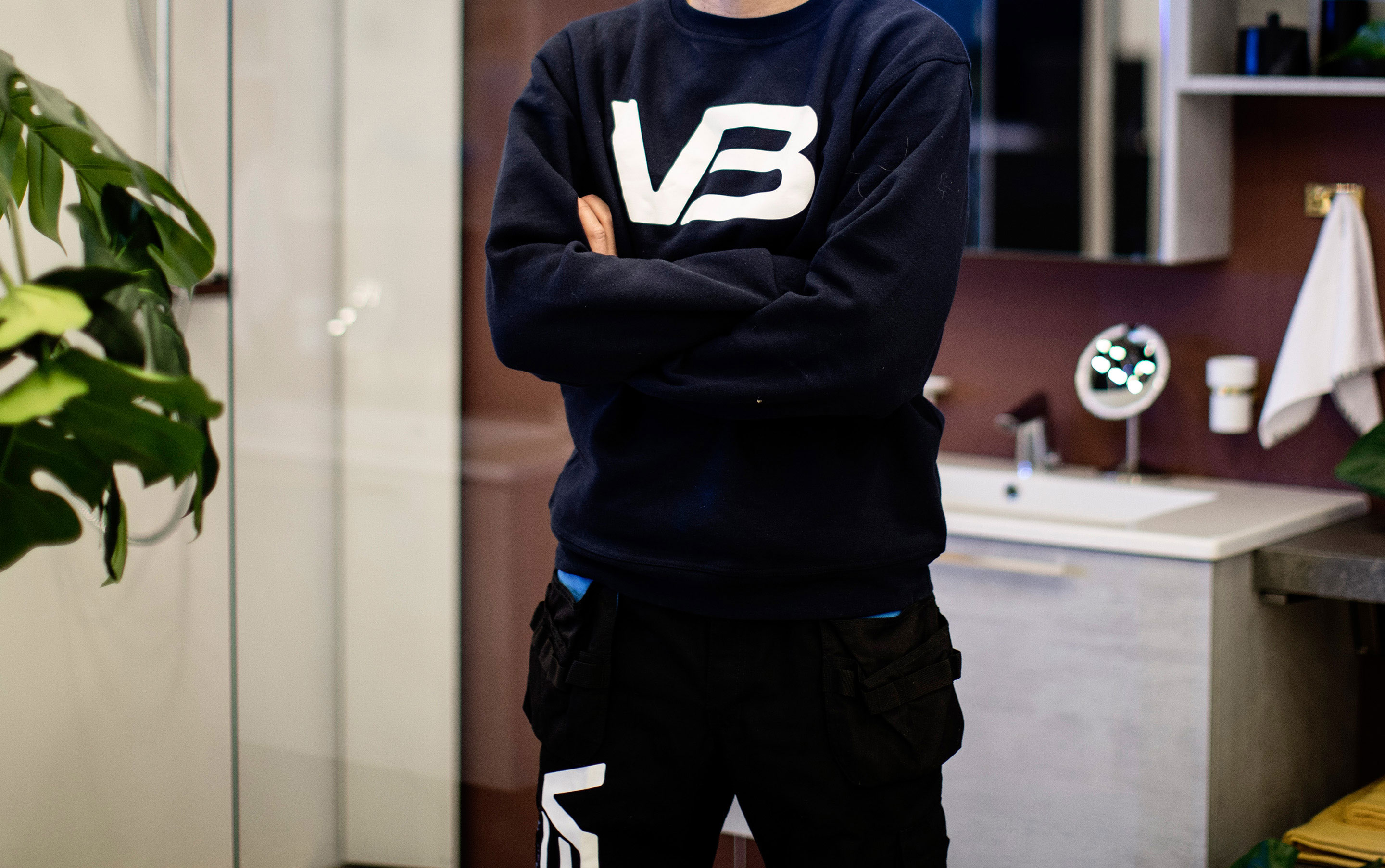 VB Rørlegger med armene i kors og med bedriftslogo på genseren sin